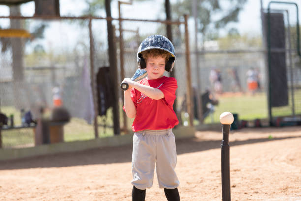 A four-year-old boy gets ready to hit a baseball during a T-ball baseball game
